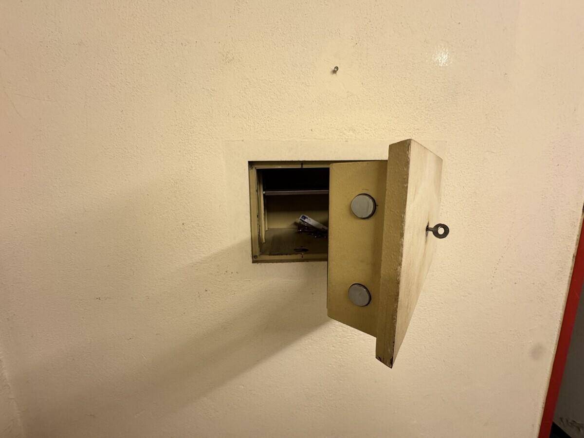 Wandtresor mit offener Tür in einer hellen Wand, möglicherweise in einem Kellerraum.