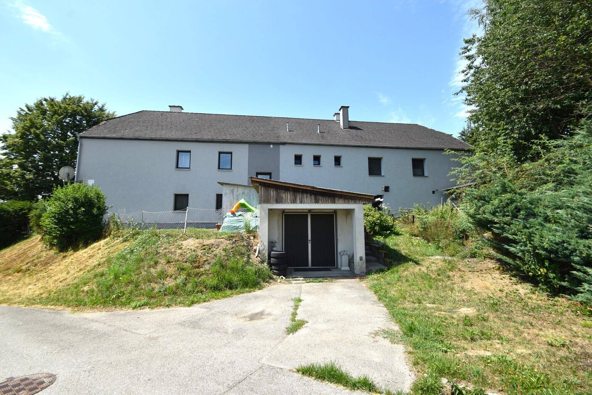 Rückseite des Gebäudes mit Garage und Zugang zu den oberen Etagen.