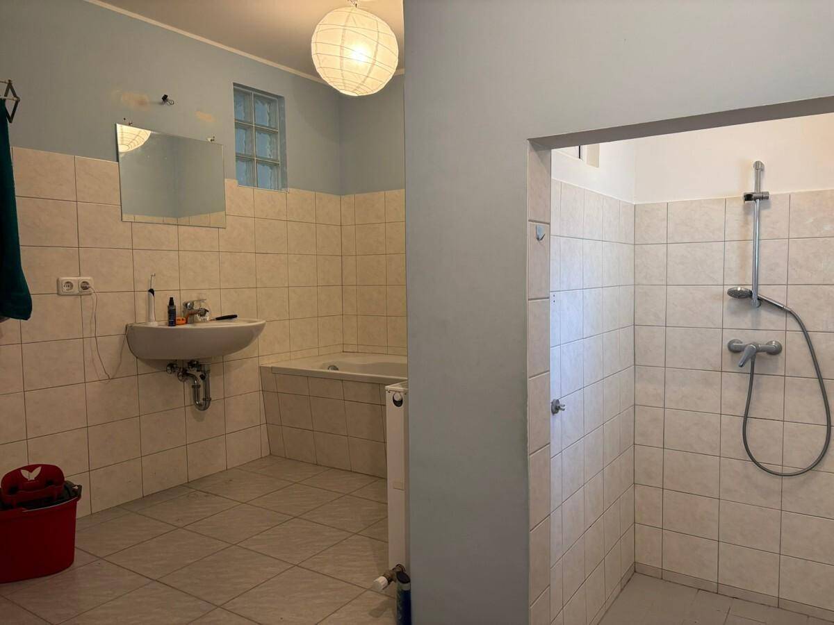 Geräumiges Badezimmer mit Badewanne, separater Dusche und hellen Fliesen.