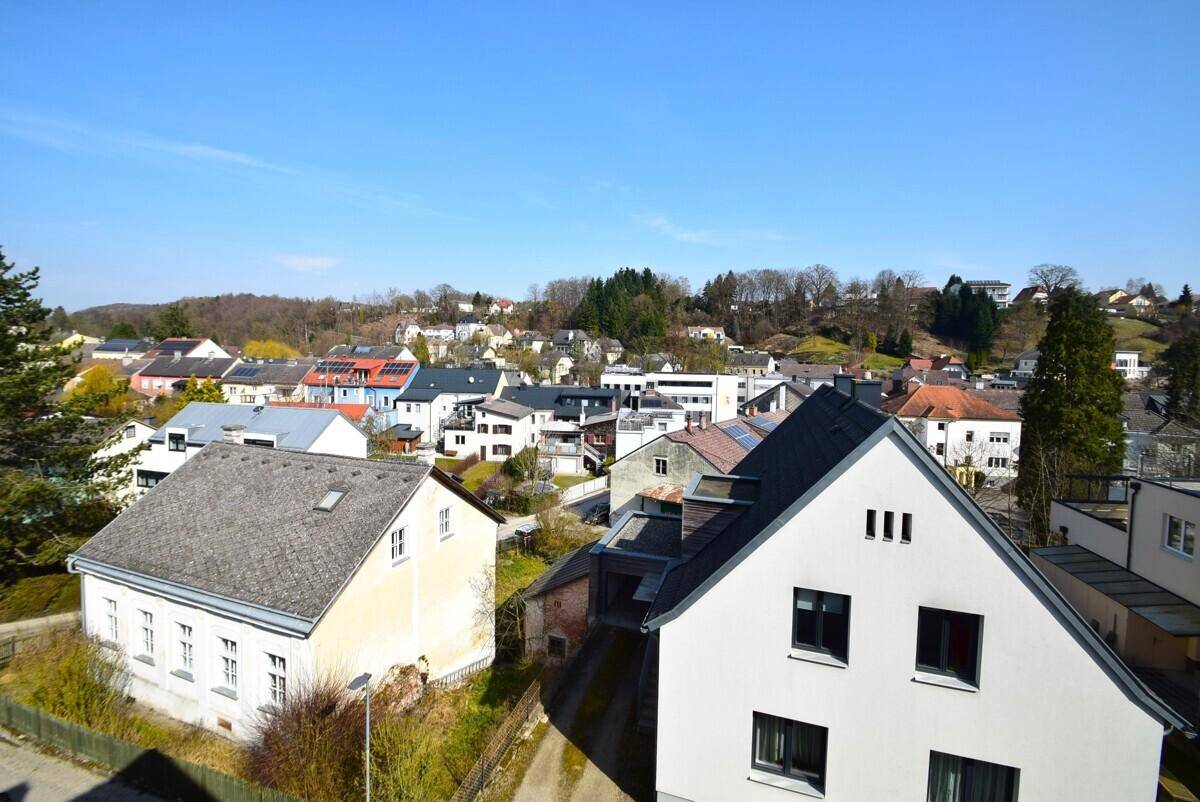 Weitläufiger Blick über die umliegende Wohnsiedlung mit vielen Häusern und grünen Hügeln.