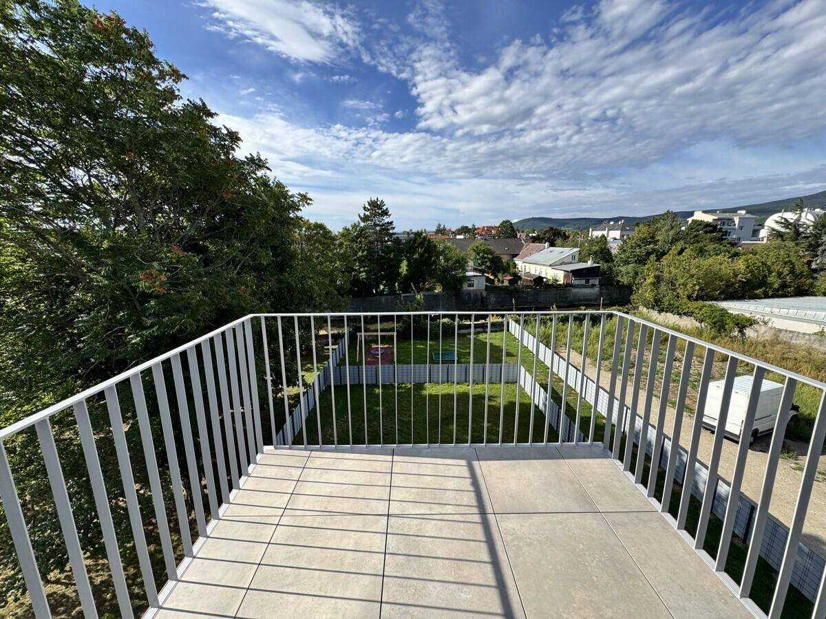 Kleiner Balkon mit Fliesenboden und Metallgeländer, bietet einen weiten Blick über die Umgebung.