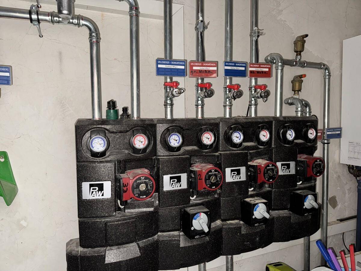 Heizungsverteiler mit Pumpen und Rohren für die Warmwasser- und Heizungsversorgung.