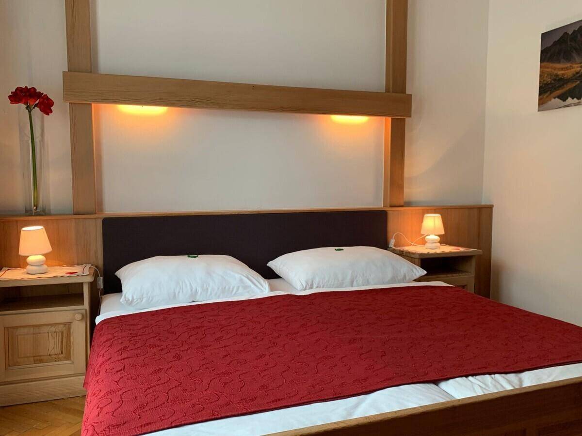 Gemütliches Schlafzimmer mit Doppelbett, Holzelementen und indirekter Beleuchtung.