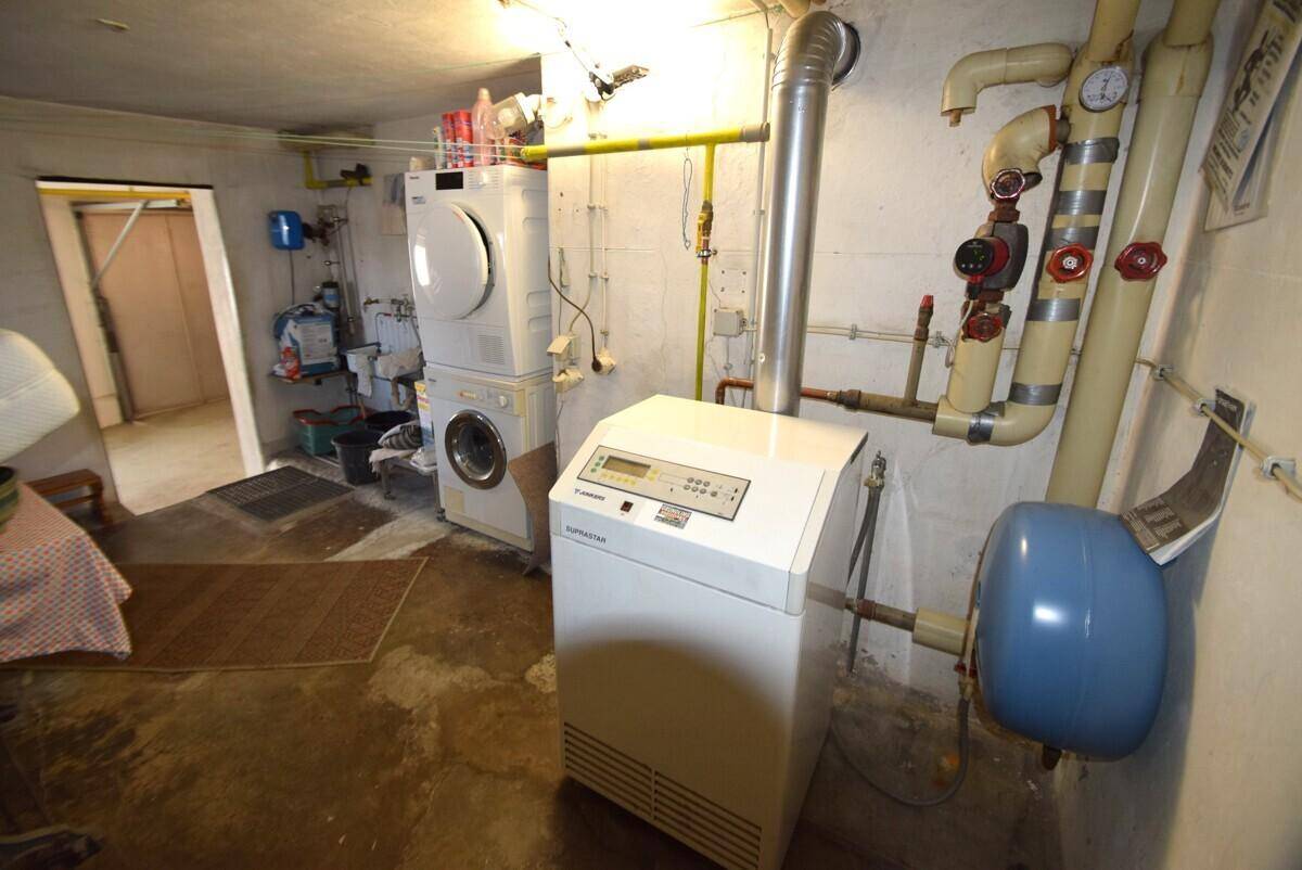 Hauswirtschaftsraum im Keller mit Heizungsanlage, Waschmaschine und Trockner.