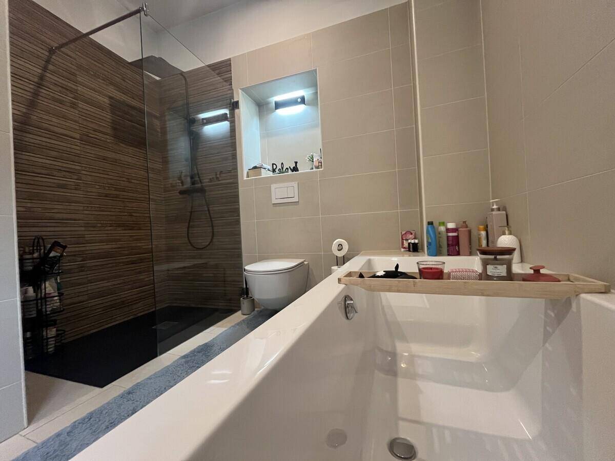 Modernes Badezimmer mit Badewanne, begehbarer Dusche und wandhängendem WC.