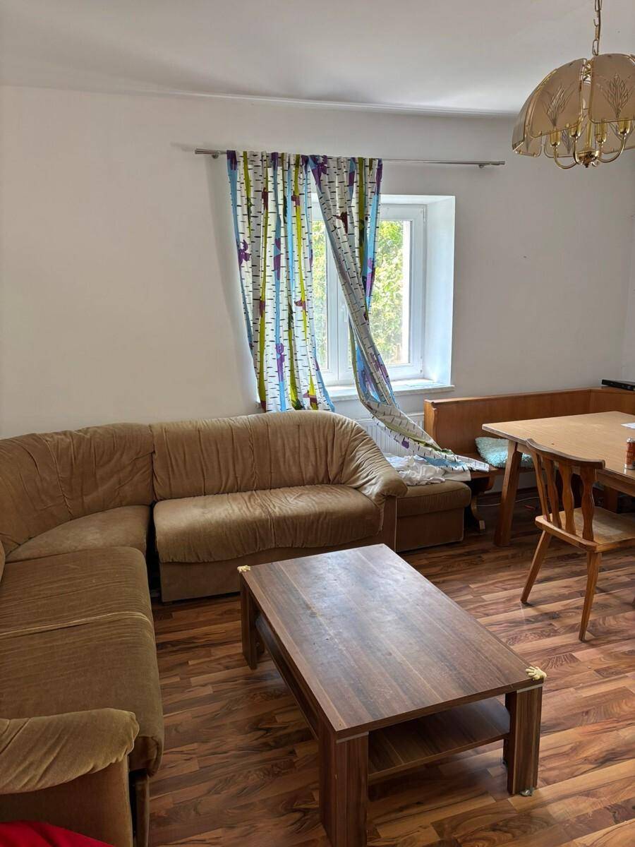 Gemütlicher Wohn- und Essbereich mit Sofa, Esstisch und Laminatboden.