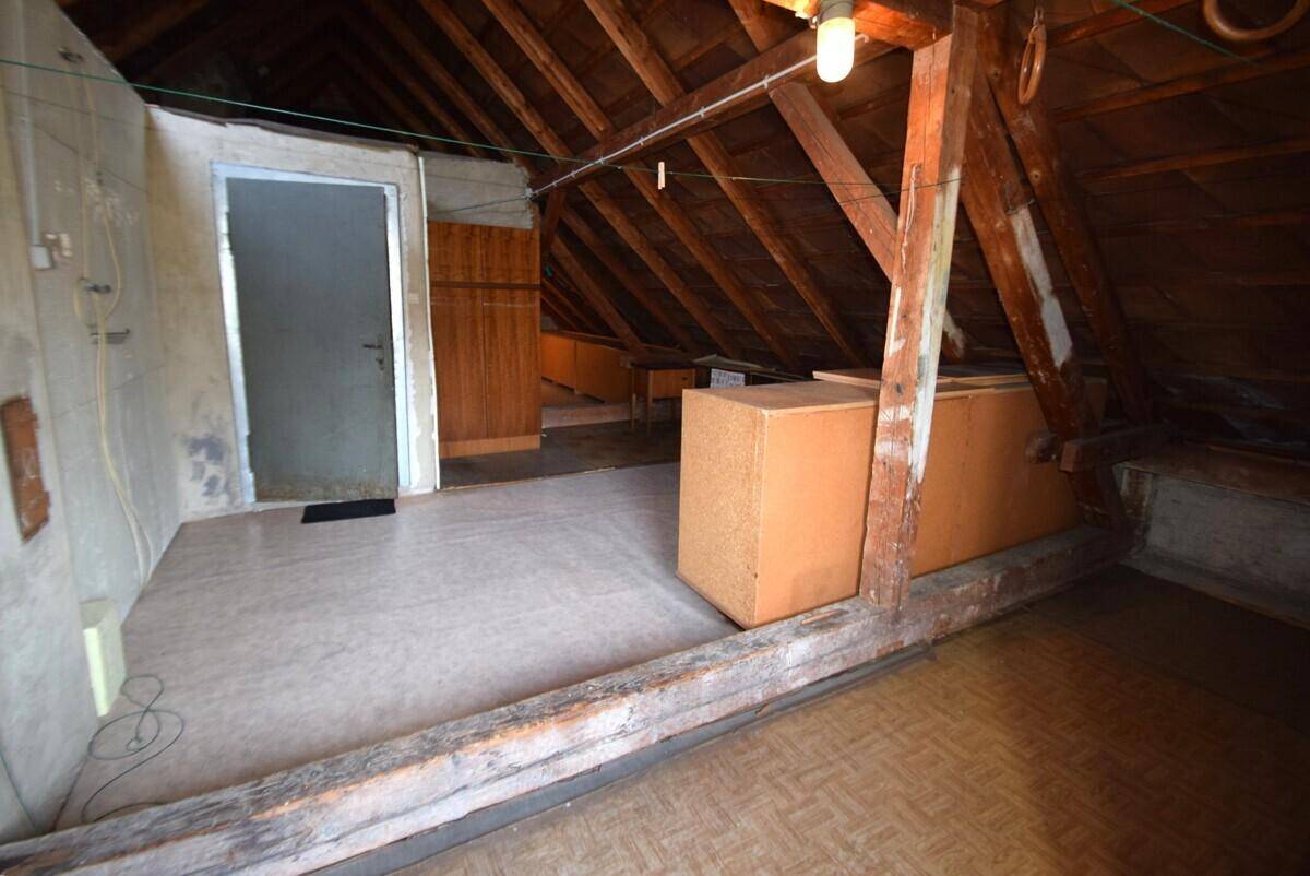 Ausgebauter Dachboden mit Holzbalken und Stauraum unter dem Dach.