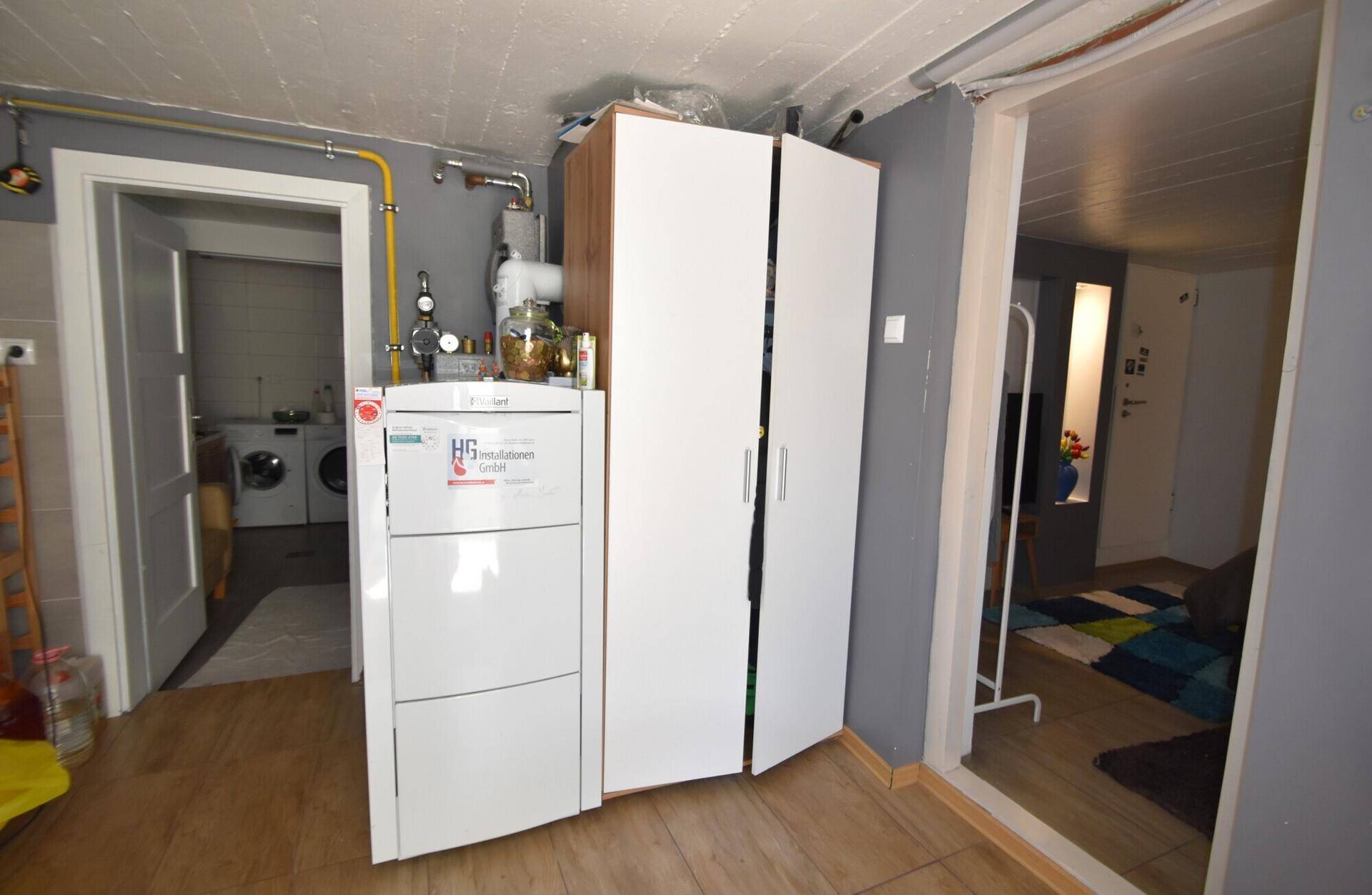Heizungsraum im Keller mit Heizungsanlage und Zugang zu weiteren Räumen.