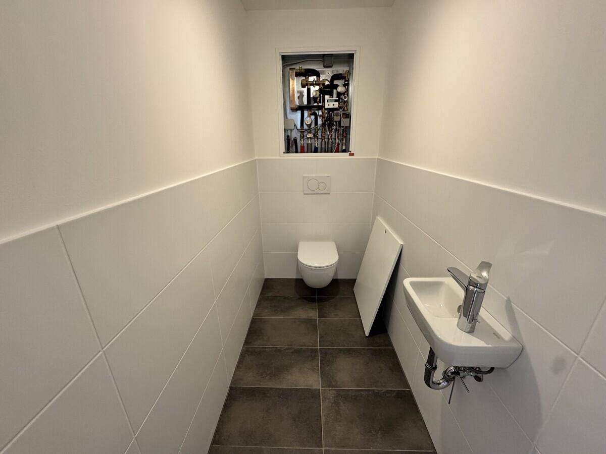 Kleines Gäste-WC mit wandhängender Toilette und einem kompakten Waschbecken.