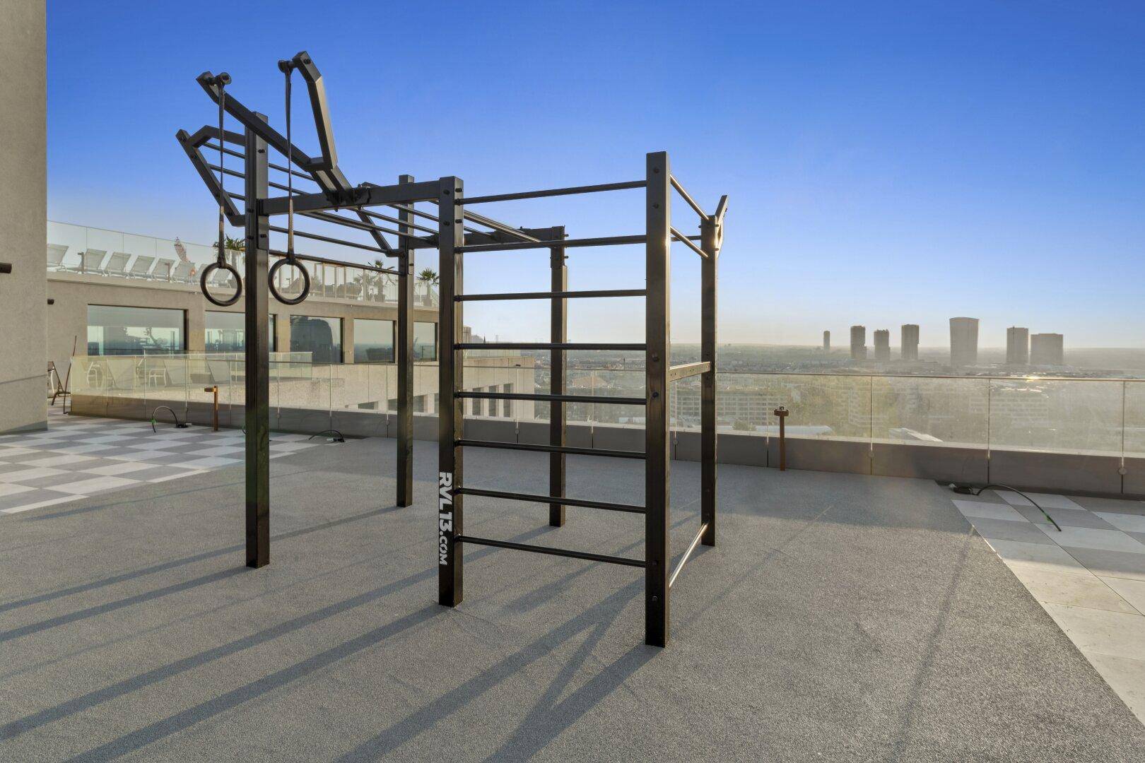 Outdoor-Fitnessbereich auf der Dachterrasse mit Panoramablick über die Stadt.