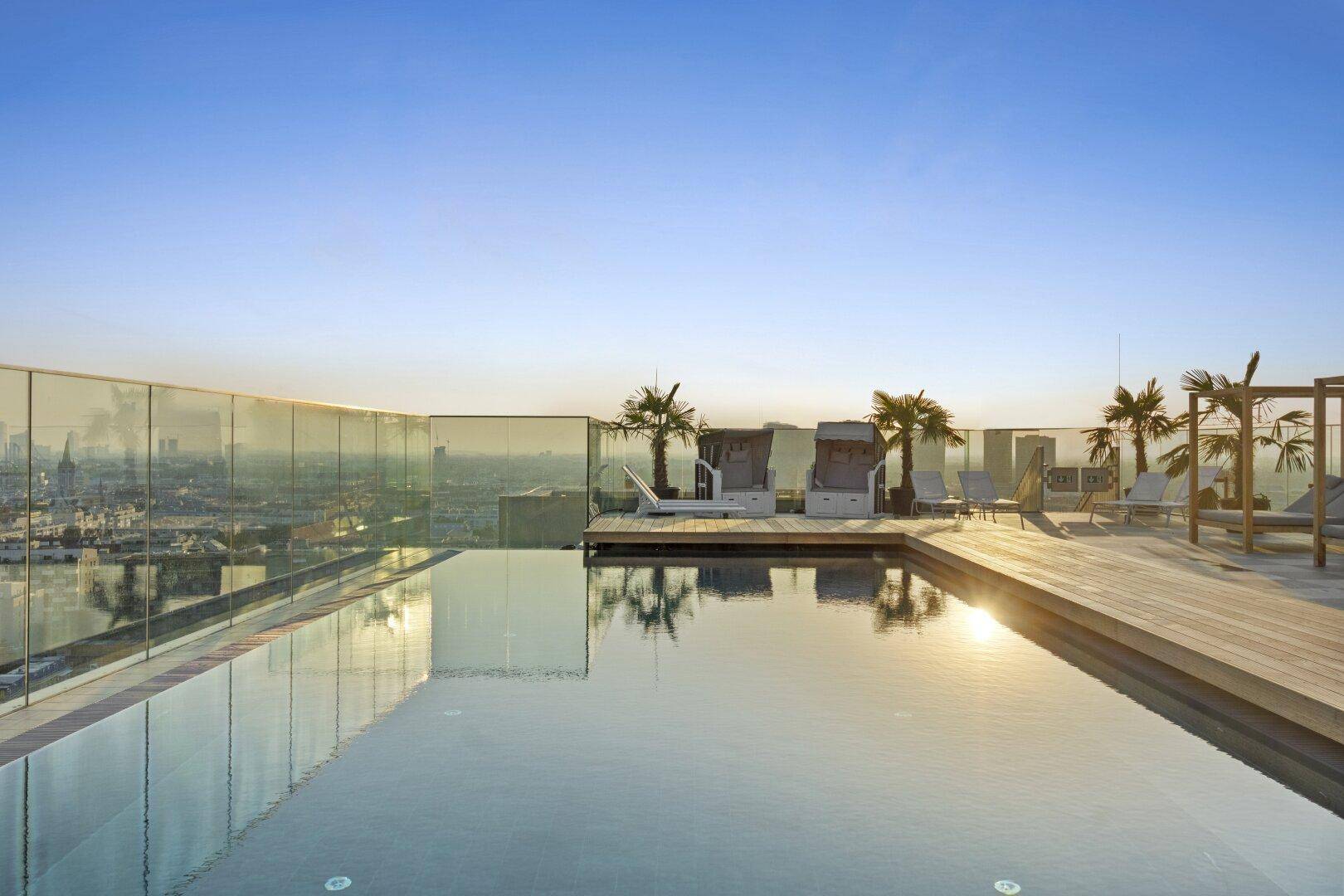 Atemberaubender Infinity-Pool auf dem Dach mit Panoramablick über die Stadt und Liegeflächen.