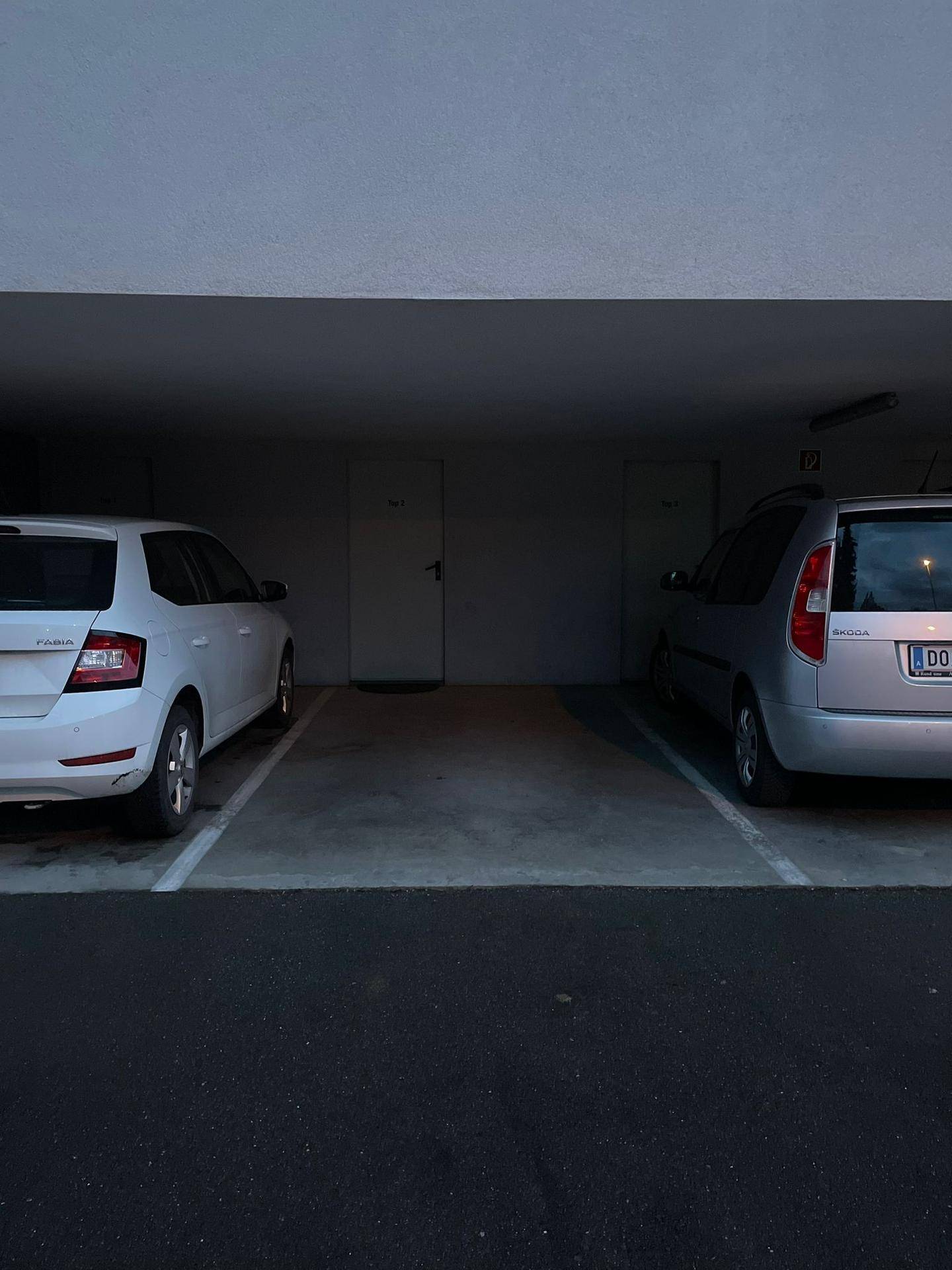 Tiefgarage mit zwei Stellplätzen und Zugangstüren zu den Wohneinheiten.