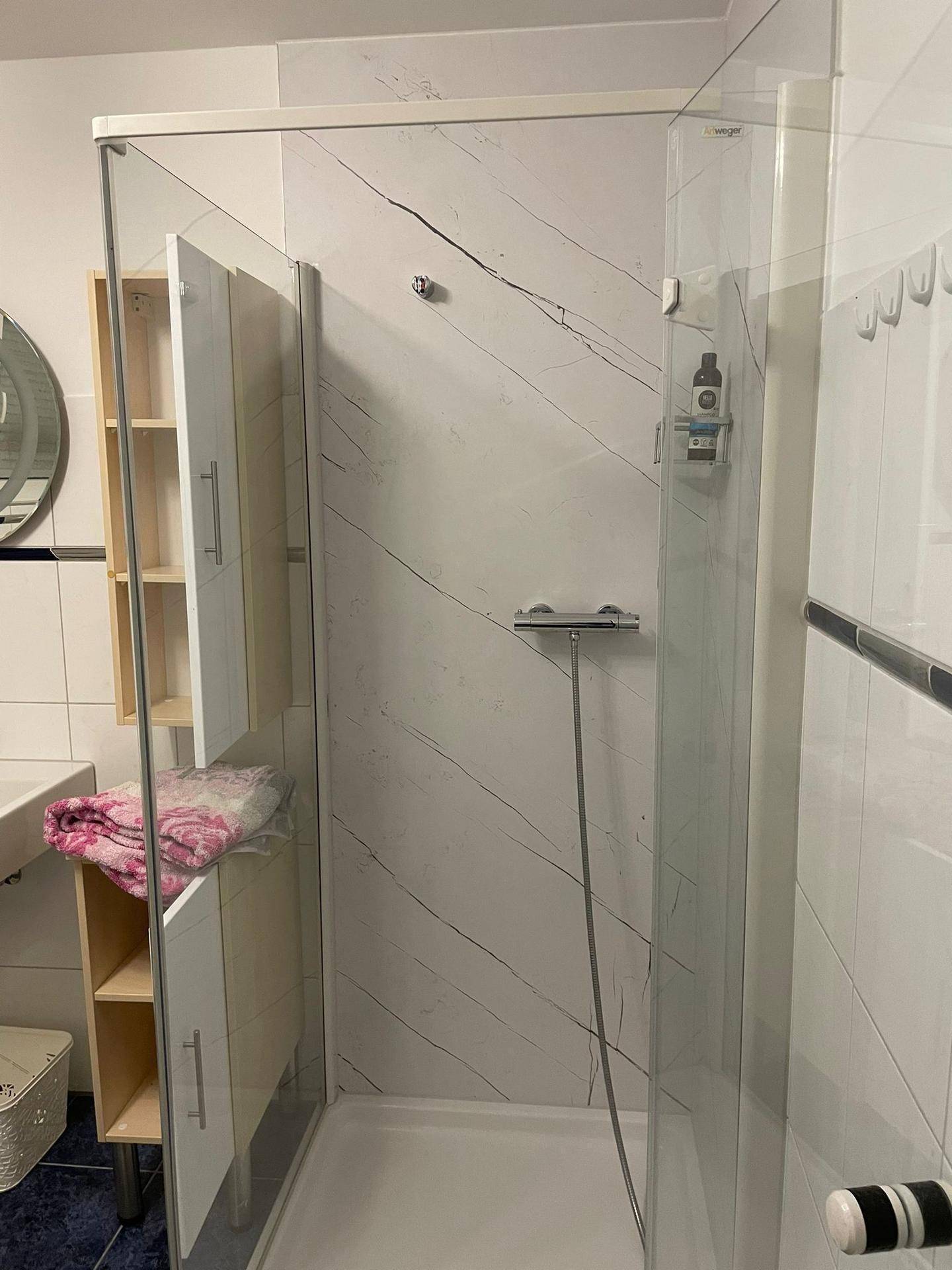Modernes Badezimmer mit einer begehbaren Dusche und einem Waschbeckenbereich.