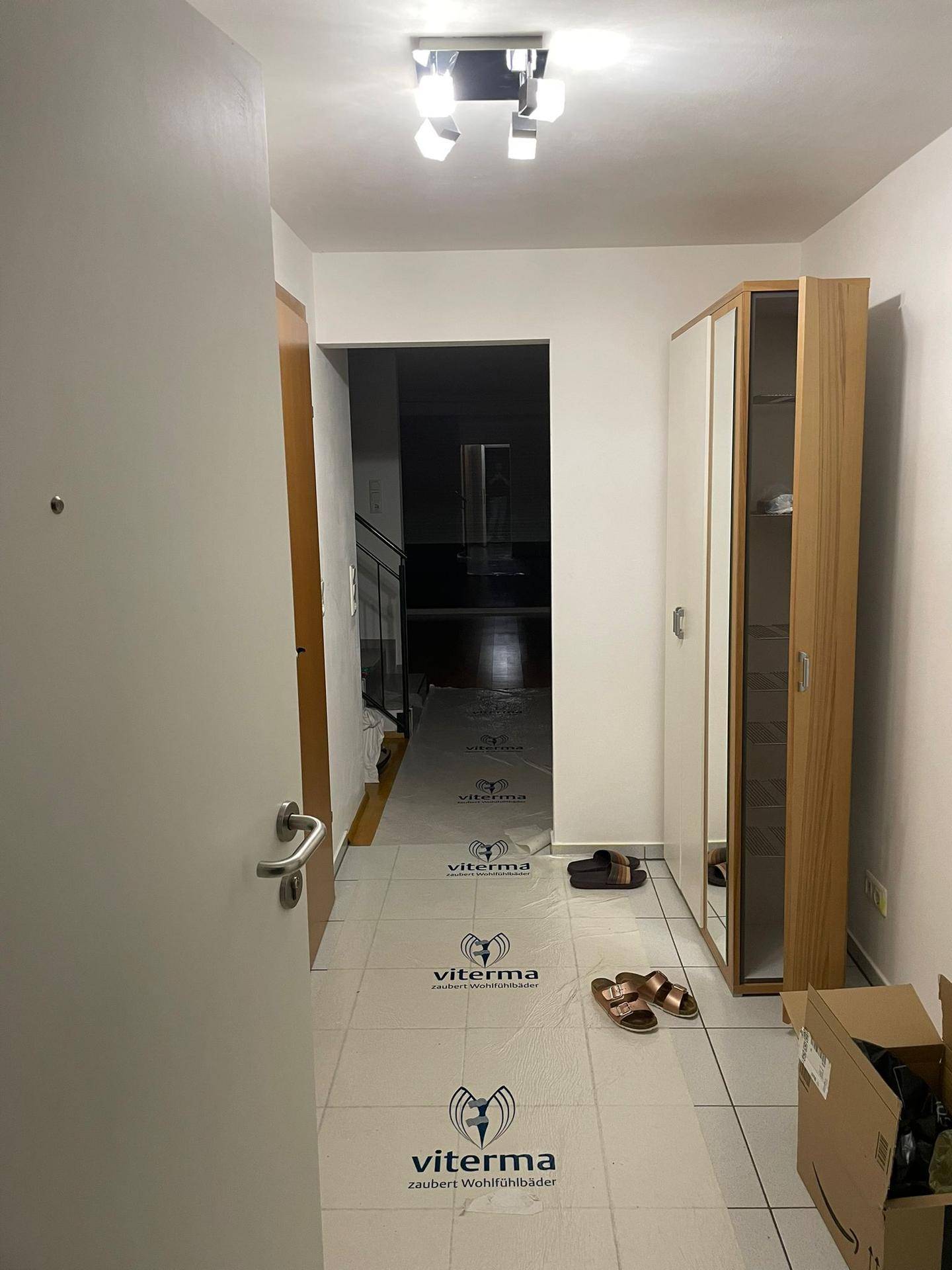 Eingangsbereich mit Fliesenboden und Garderobenschrank, führt in den Wohnbereich.