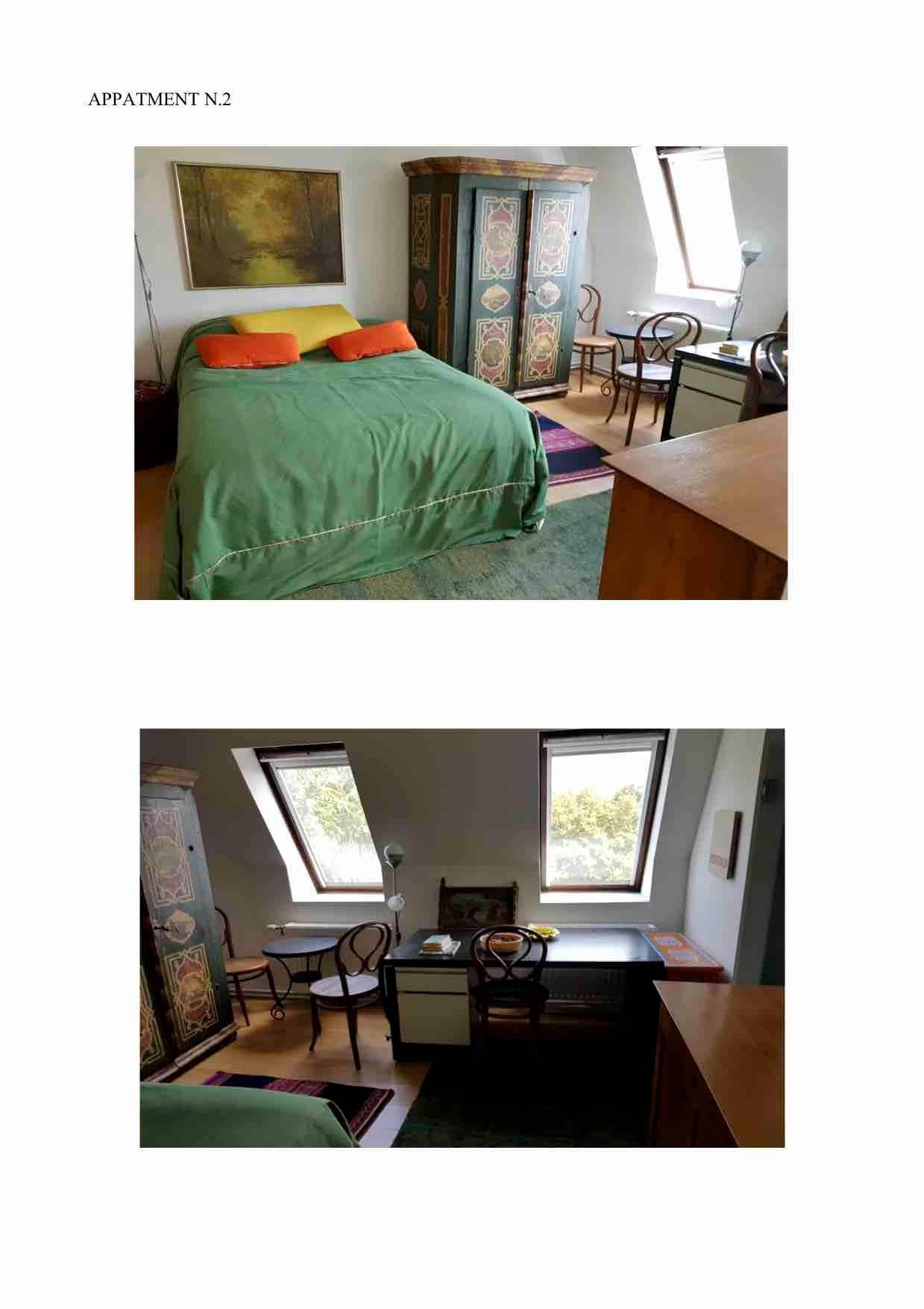 Dachgeschoss-Schlafzimmer mit farbenfrohem Schrank, Bett und Arbeitsbereich unter Dachfenstern.