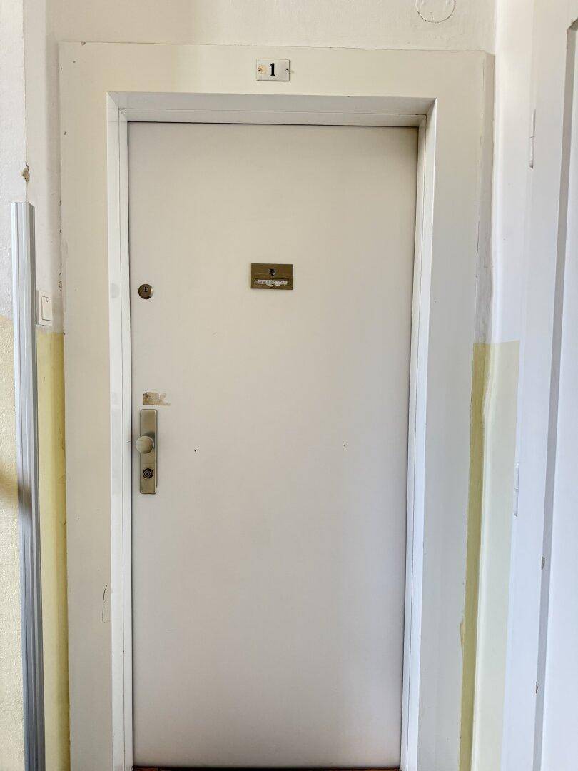 Eingangstür einer Wohnung mit der Nummer 1 in einem Mehrfamilienhaus.