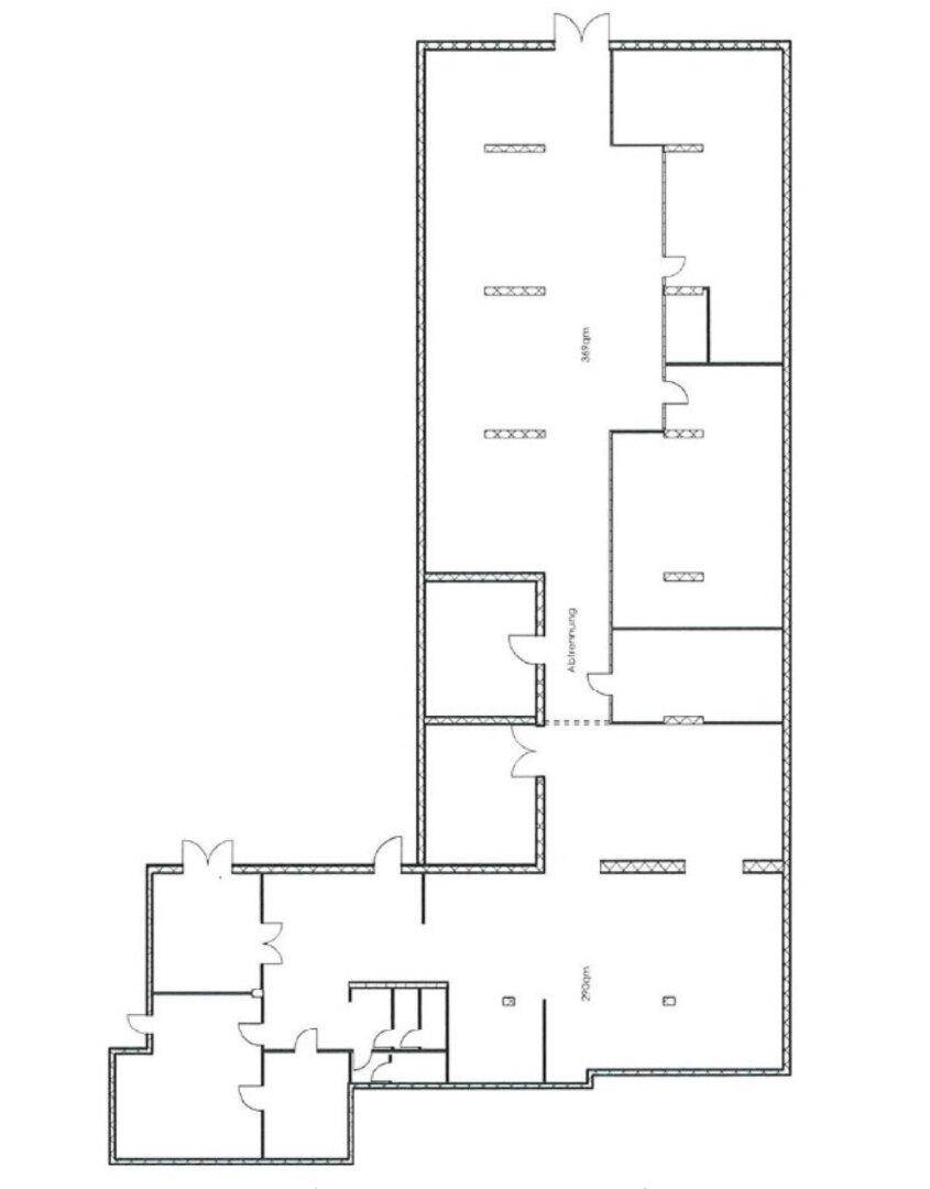 Schwarz-weißer Grundriss eines Stockwerks mit großen offenen Bereichen und Treppenhaus.