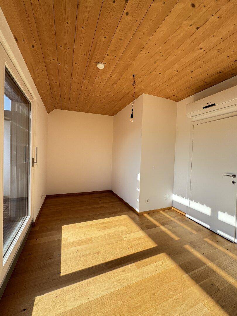Geräumiges Zimmer mit Holzbalkendecke, Parkettboden und Klimaanlage, bereit zum Einrichten.