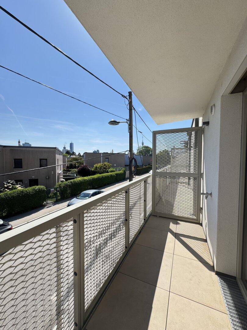 Balkon mit Metallgeländer und Blick auf die Stadt und die Umgebung.