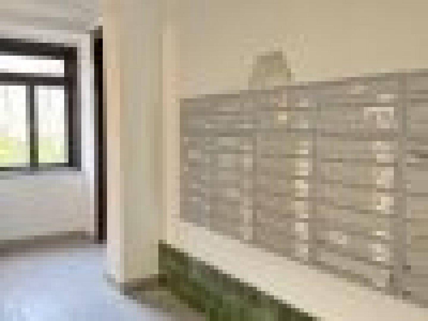 Eingangsbereich mit zahlreichen Briefkästen und einem Fenster, das den Raum erhellt.