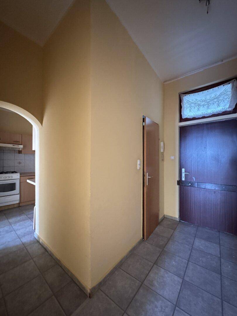 Eingangsbereich mit Fliesenboden und Zugang zur Küche sowie weiteren Zimmern.