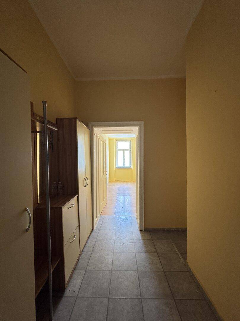 Heller Flur mit Fliesenboden und Garderobe, der den Zugang zu weiteren Räumen ermöglicht.