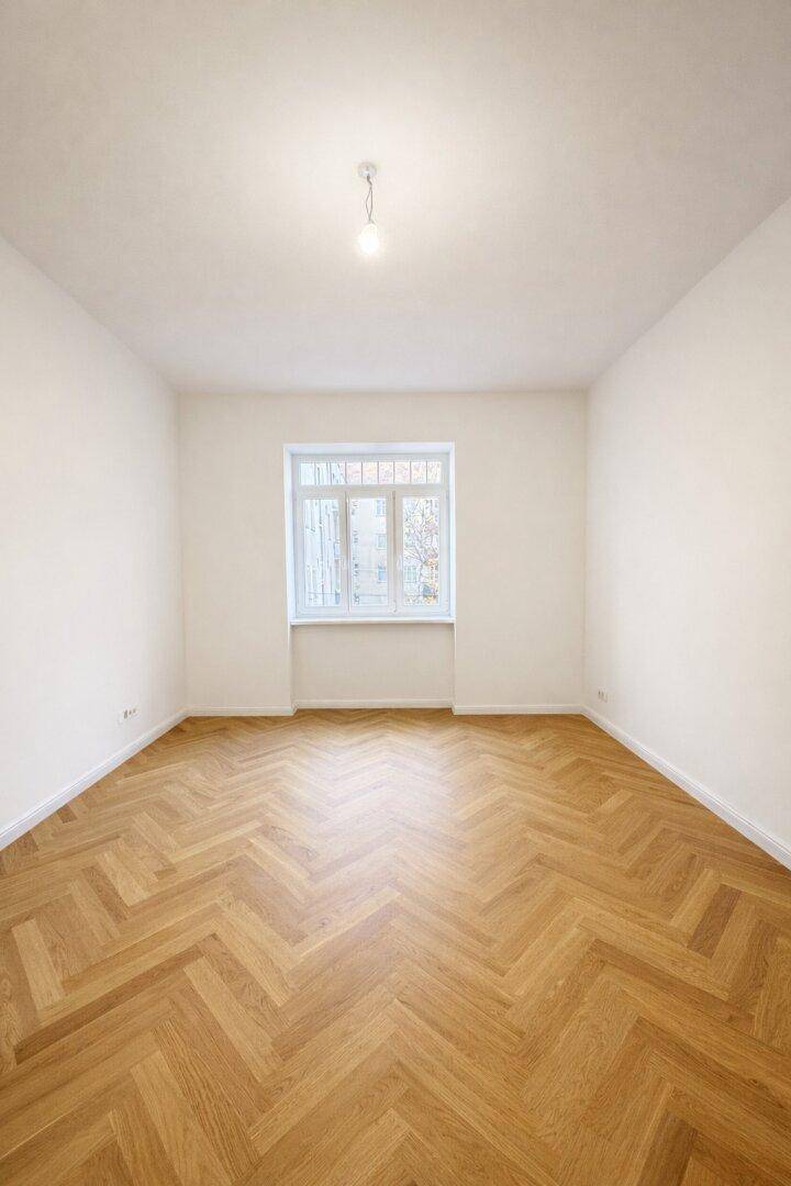 Helles und geräumiges Zimmer mit Fischgrätparkett und großem Fenster, vielseitig nutzbar.