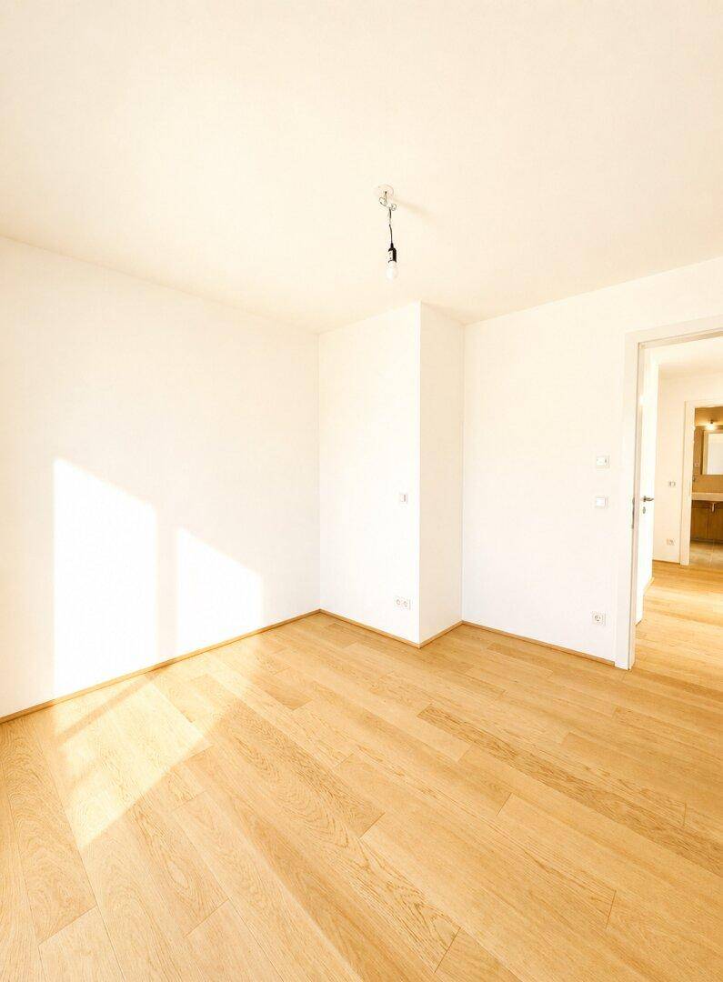 Helles Zimmer mit Parkettboden und viel Tageslicht, ideal als Schlaf- oder Arbeitszimmer.