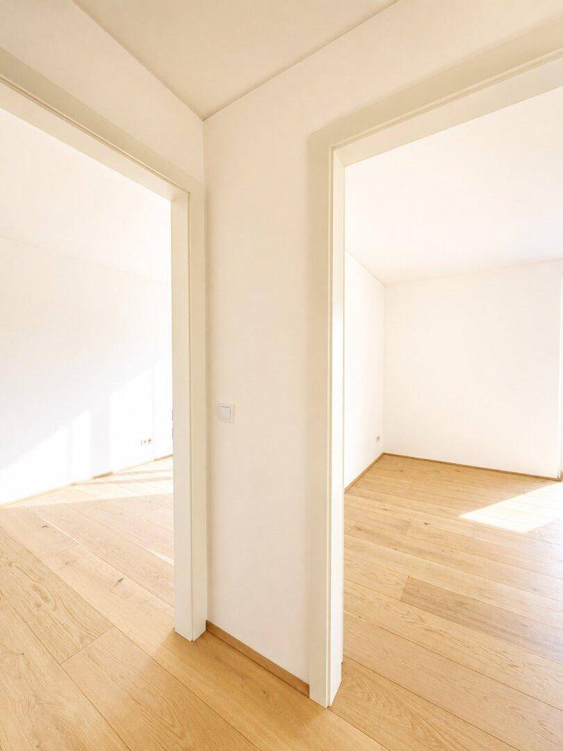 Heller Flur mit zwei offenen Türen, die den Blick in weitere Räume freigeben.