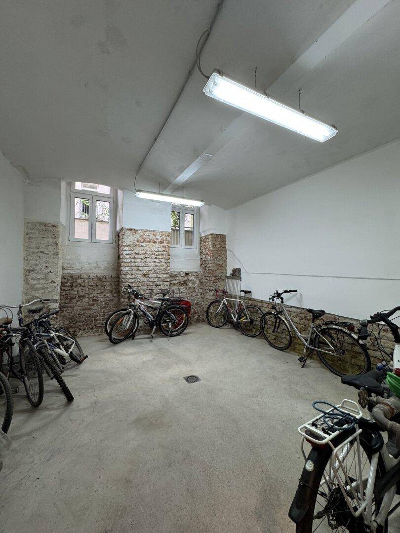 Fahrradraum im Keller mit mehreren Fahrrädern und Fenstern, bietet praktischen Stauraum.