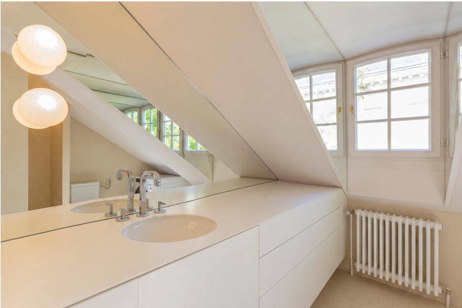 Modernes Badezimmer mit Waschtisch, großem Spiegel und Fenstern im Dachgeschoss.