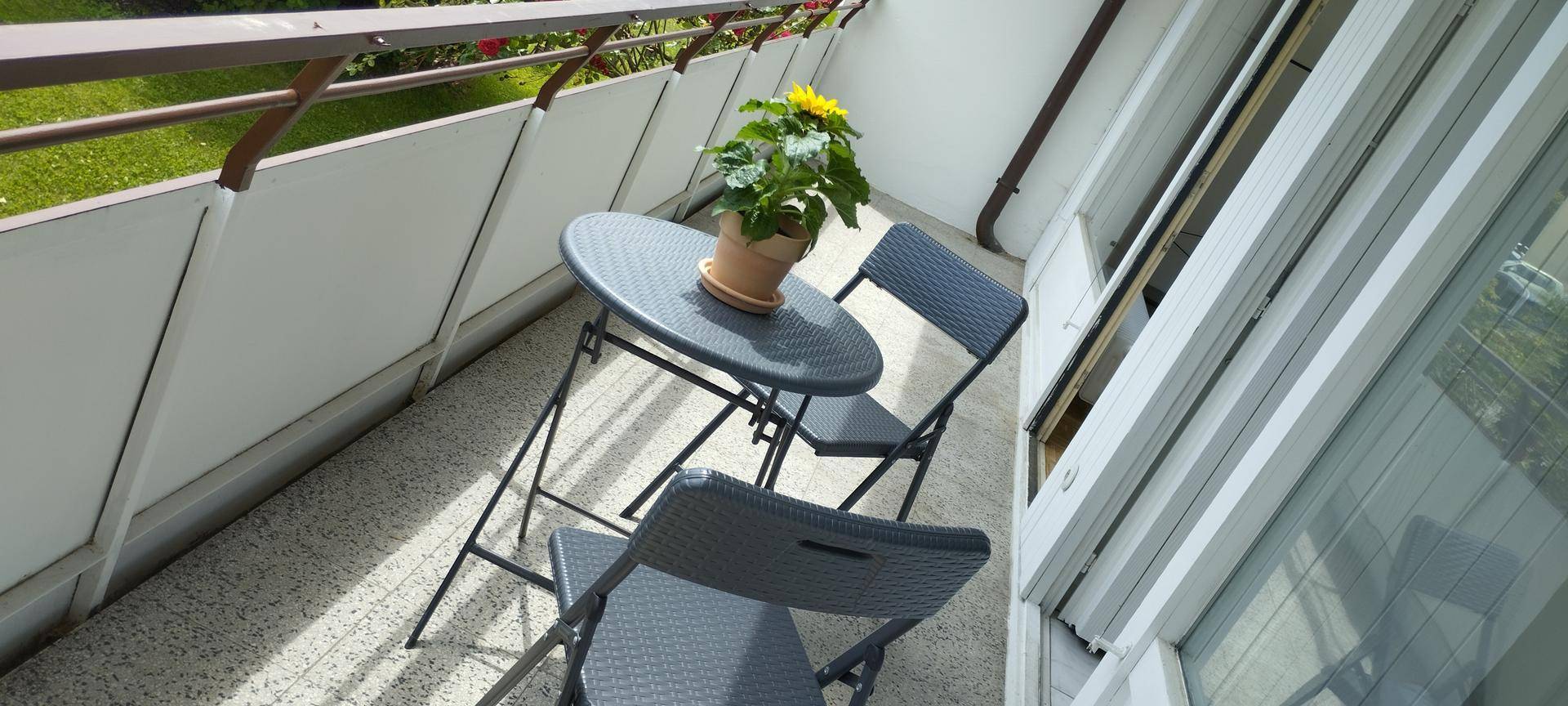 Kleiner Balkon mit Sitzgelegenheiten und Blick ins Grüne.