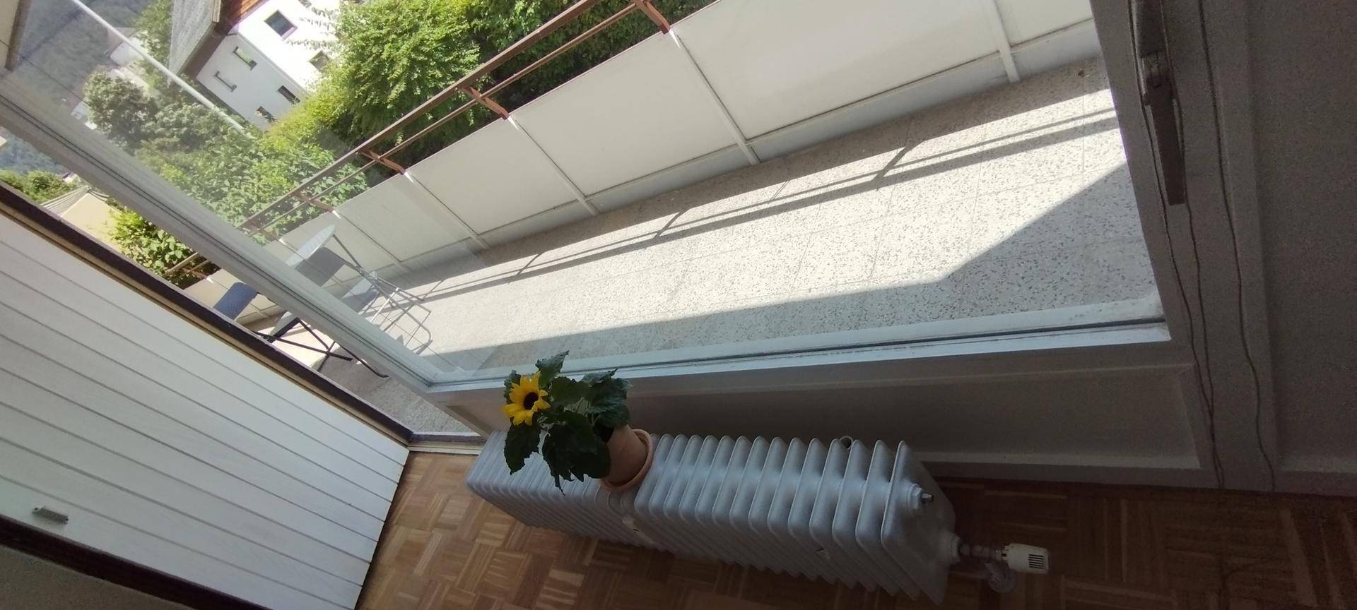 Innenansicht mit Blick auf den Balkon, der eine helle Bodenfläche und ein Geländer aufweist.