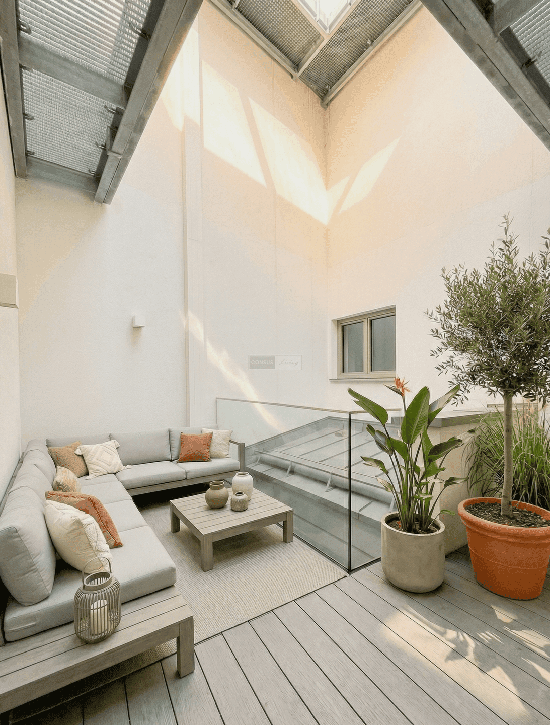 Gemütliche Dachterrasse mit bequemen Loungemöbeln und Pflanzen unter einer modernen Überdachung.