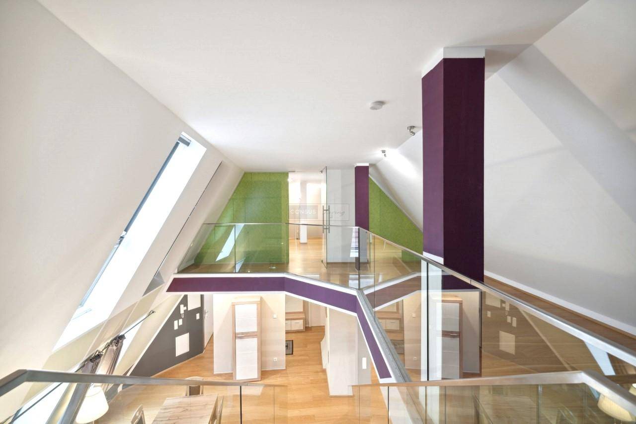 Heller, offener Wohnbereich über mehrere Ebenen mit moderner Glasbrüstung und Holzboden.