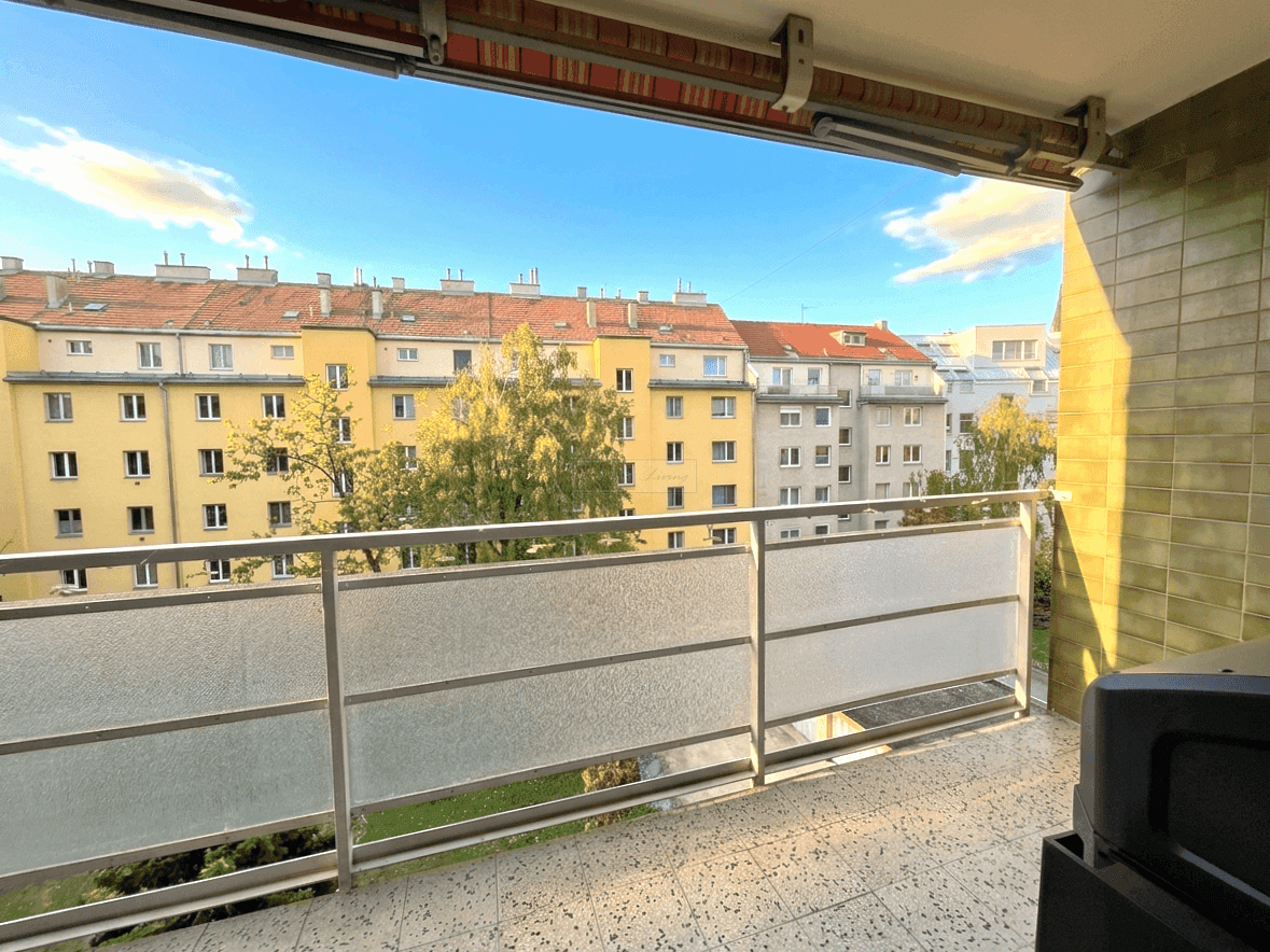 Heller Balkon mit Weitblick über die Dächer der Stadt und sonnigem Himmel.