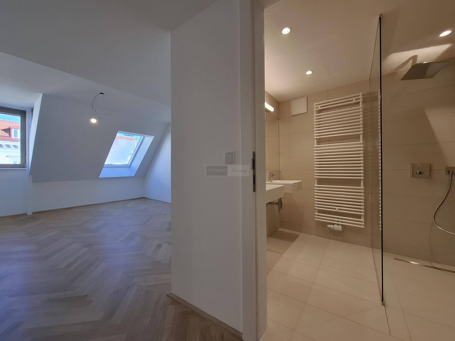 Modernes Badezimmer mit ebenerdiger Dusche, Handtuchheizkörper und Blick in einen Wohnraum.