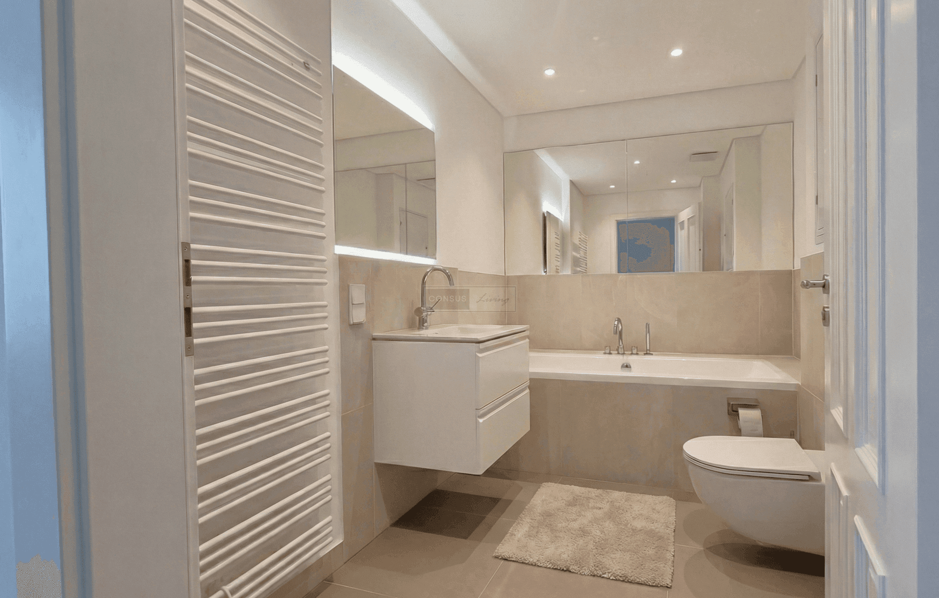 Elegantes Badezimmer mit Badewanne, modernem Waschtisch und beheiztem Handtuchhalter.