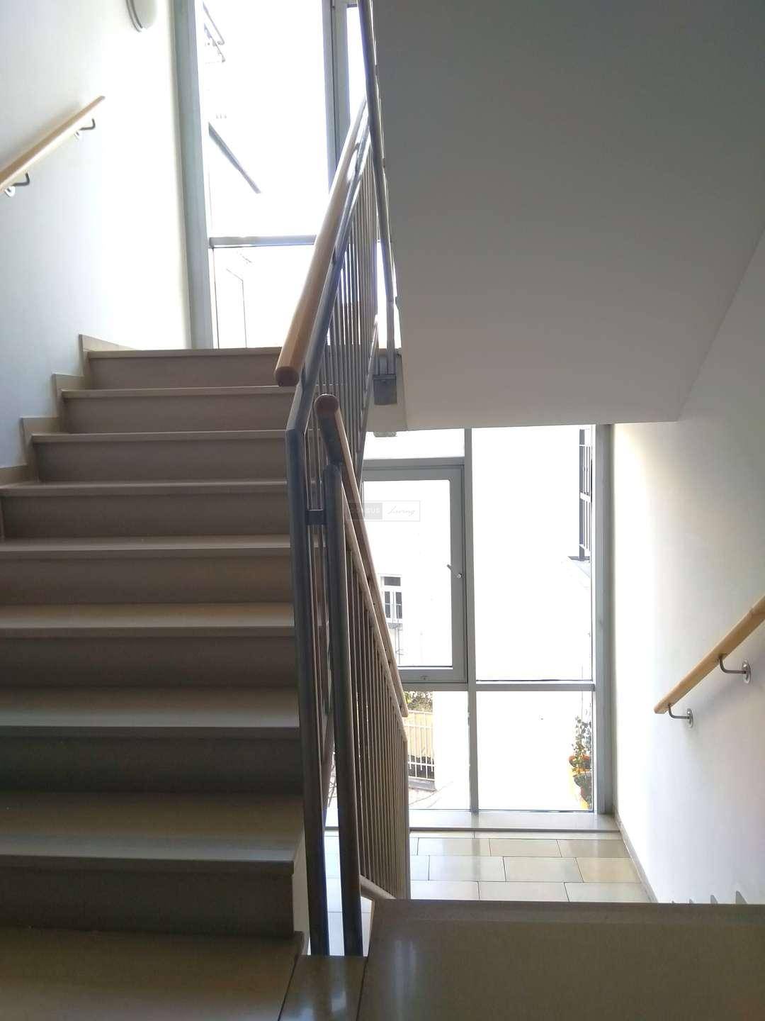 Helles Treppenhaus mit großen Fenstern, die für viel natürliches Licht sorgen.