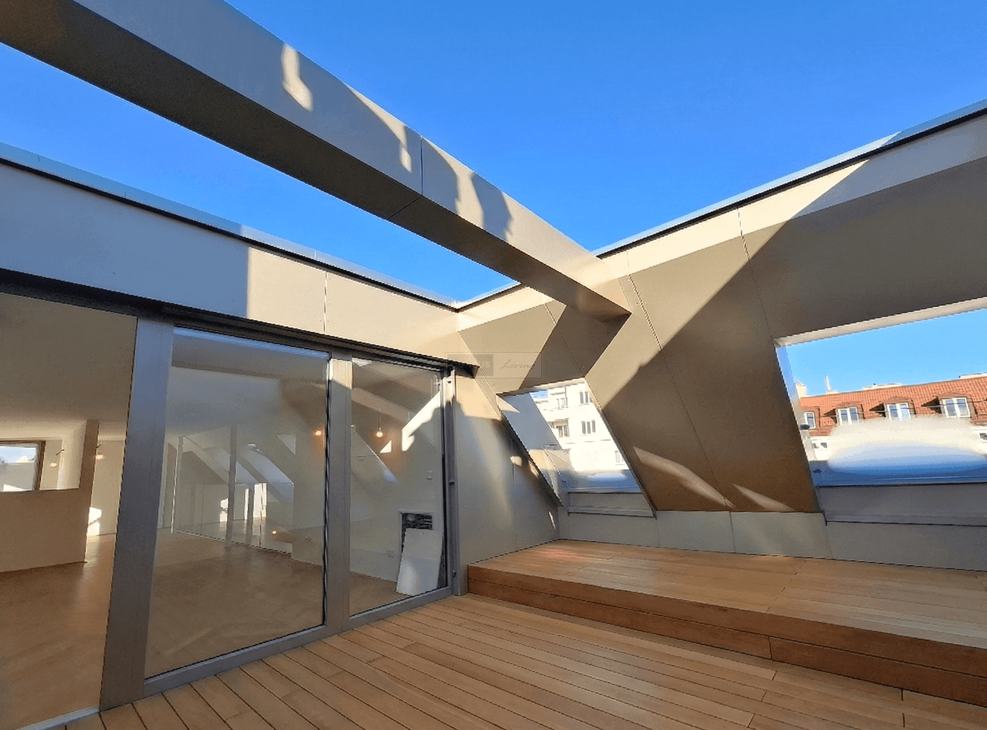 Geräumige Dachterrasse mit Holzboden und Schiebetüren, die den Innenbereich mit dem Außenbereich verbinden.