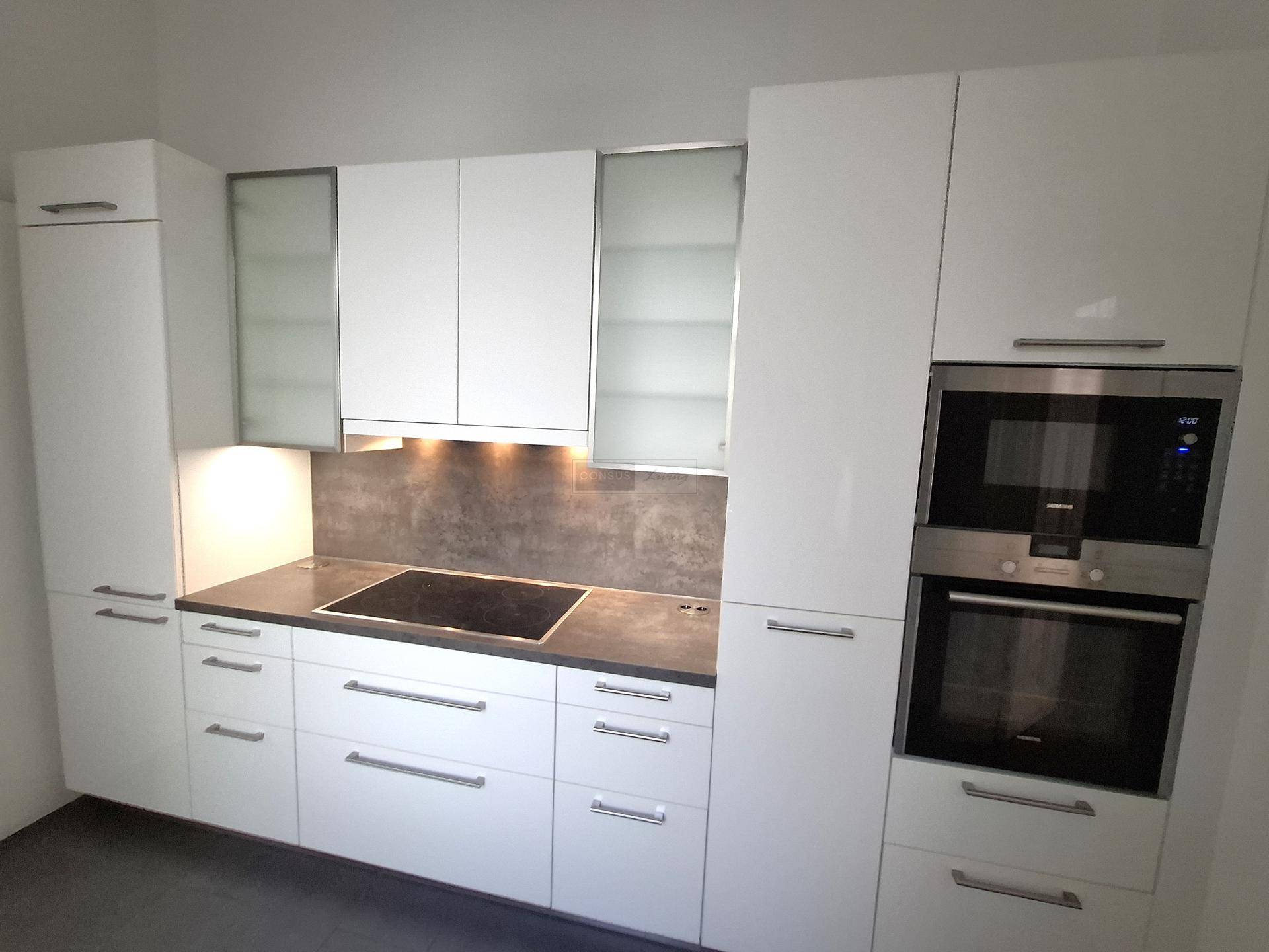 Helle Einbauküche mit weißen Fronten, modernen Geräten und Induktionskochfeld.