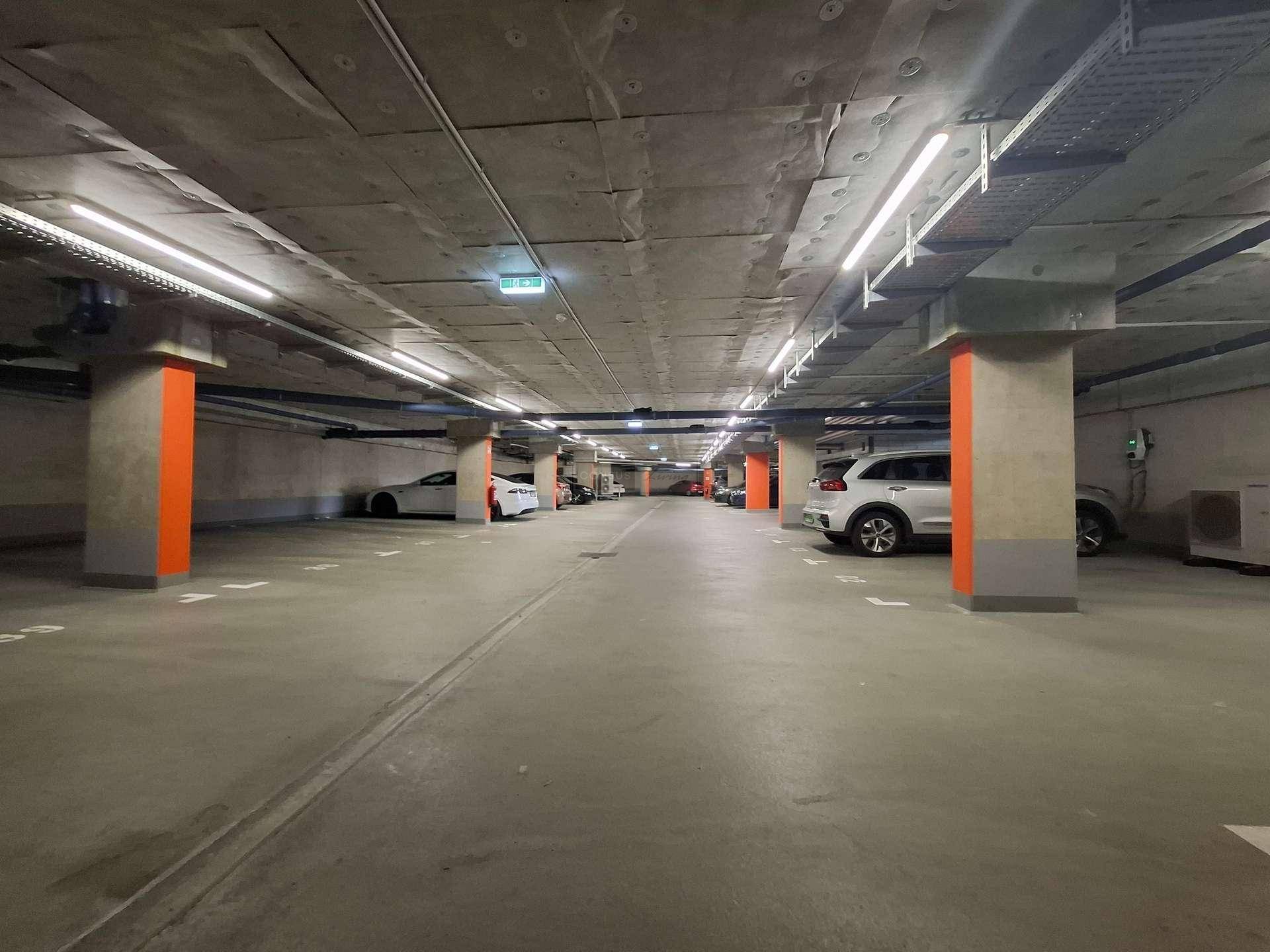 Tiefgarage mit zahlreichen Stellplätzen und moderner Beleuchtung.