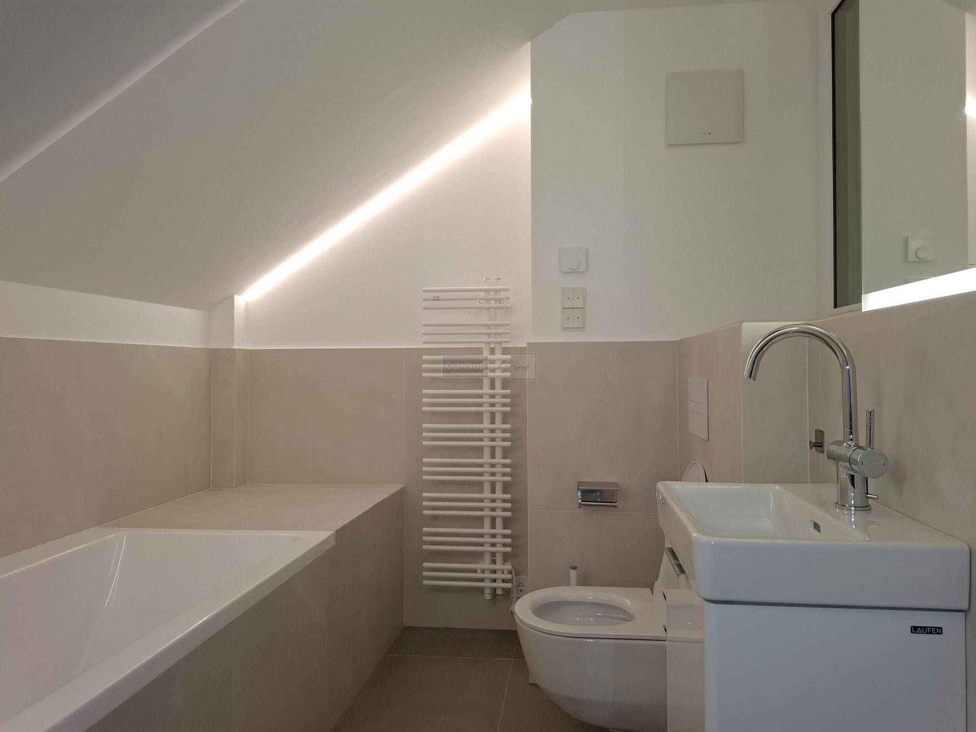 Modernes Badezimmer mit Badewanne, wandhängendem WC und integrierter Beleuchtung.