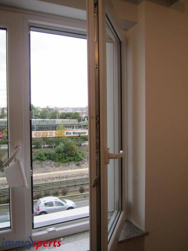 Offenes Fenster mit Blick auf eine belebte Straße und die städtische Umgebung.