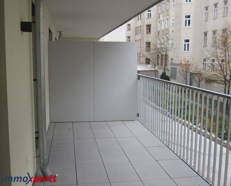 Geräumiger Balkon mit Fliesenboden und seitlichem Sichtschutz, bietet Privatsphäre.