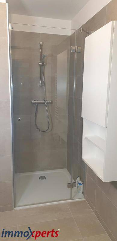 Modernes Badezimmer mit ebenerdiger Dusche und Glasabtrennung, sehr geräumig.