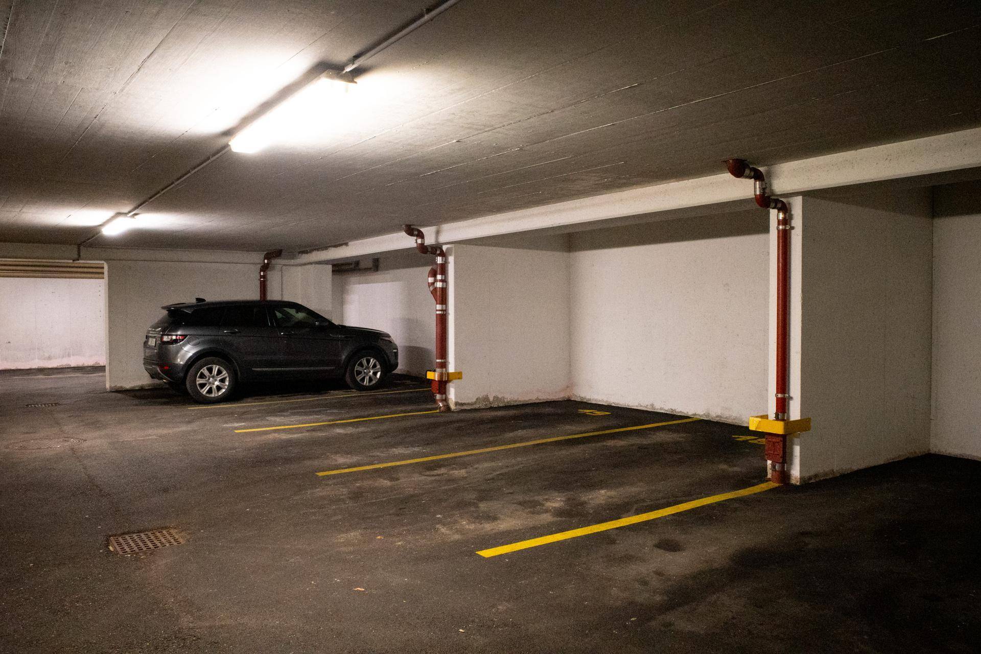 Tiefgaragenstellplatz mit gelben Bodenmarkierungen und einem geparkten SUV.