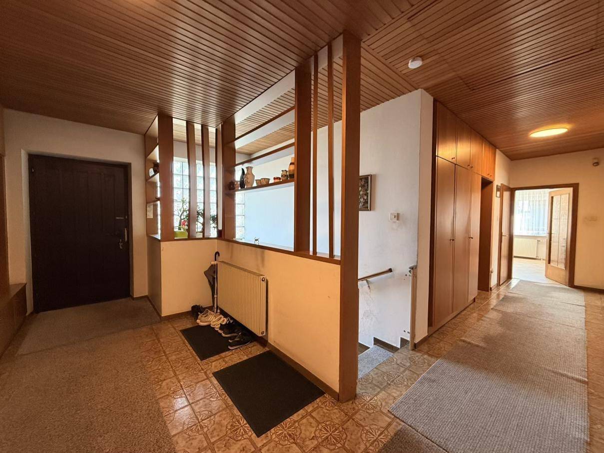Geräumiger Flur mit Holzvertäfelung, integrierten Schränken und einem Heizkörper an der Wand.
