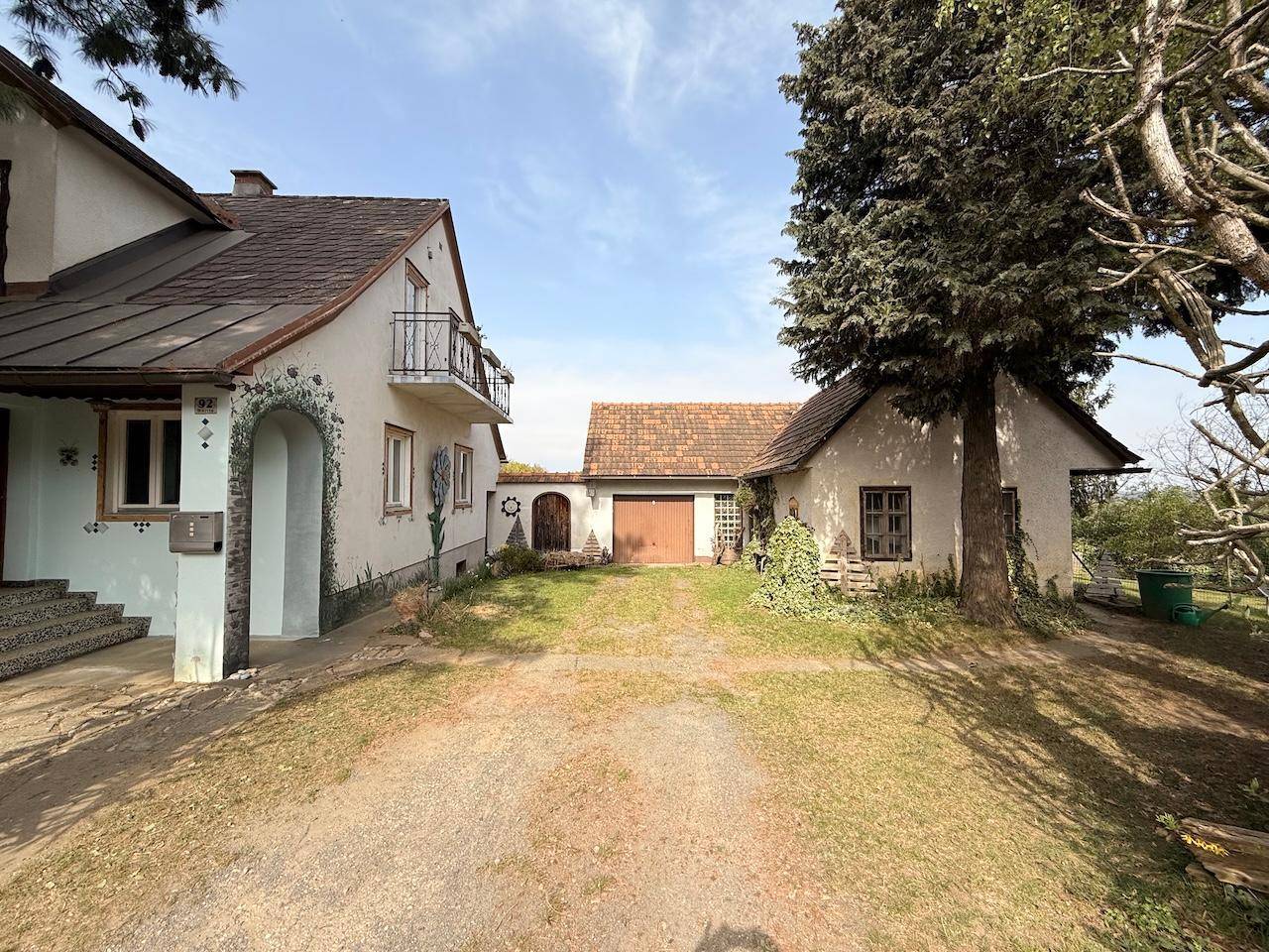 Blick auf das Wohnhaus mit angrenzender Garage und Zufahrt auf dem Grundstück.