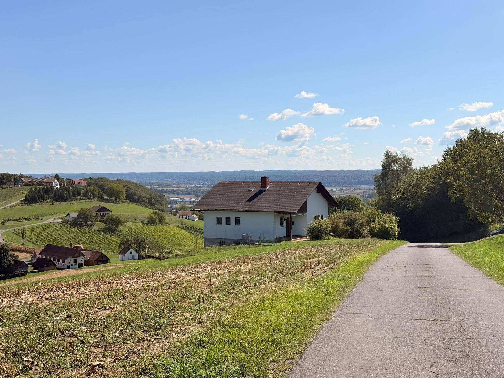 Panoramablick auf das Haus in ländlicher Umgebung mit Weinbergen und weitem Horizont.